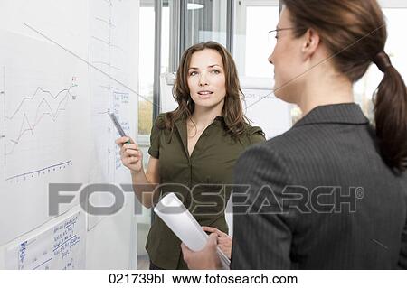 two businesswoman having discussion in front of whiteboard View Large Photo Image Stock Image - two businesswoman having discussion in front of whiteboard. Fotosearch