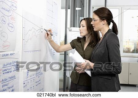 two businesswomen in front of whiteboard View Large Photo Image Stock Image - two businesswomen in front of whiteboard. Fotosearch