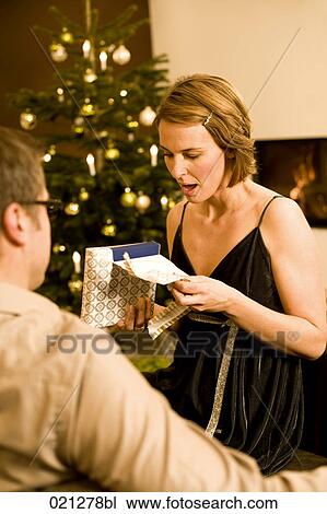 woman opening christmas present from man View Large Photo Image Stock Image - woman opening christmas present from man. Fotosearch