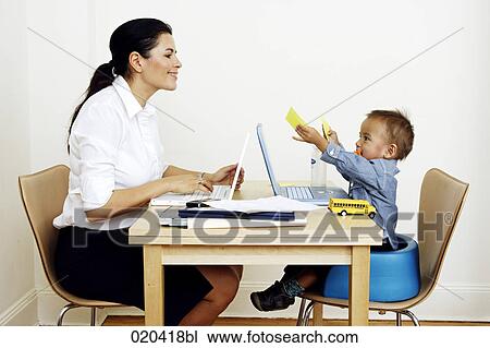 woman working from home sitting at table with little son View Large Photo Image Stock Image - woman working from home sitting at table with little son. Fotosearch
