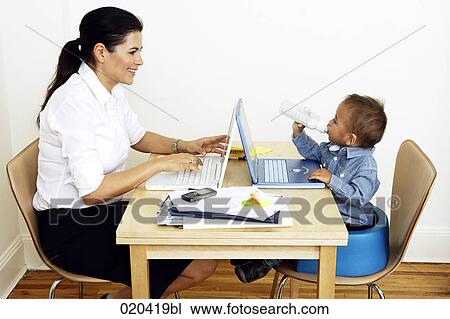 woman working from home sitting at table with little son View Large Photo Image Stock Image - woman working from home sitting at table with little son. Fotosearch