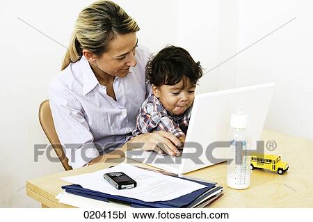 woman working from home with laptop computer sitting with little son at table View Large Photo Image Stock Image - woman working from home with laptop computer sitting with little son at table. Fotosearch
