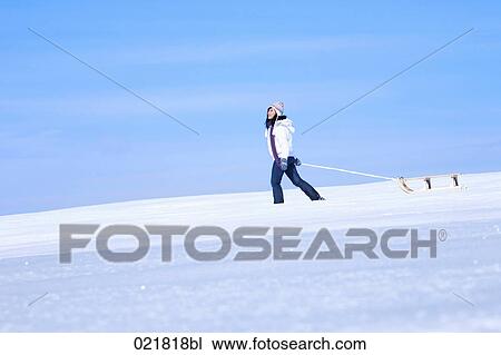 young asian woman in winter pulling sledge through snow View Large Photo Image Stock Image - young asian woman in winter pulling sledge through snow. Fotosearch