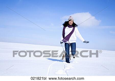 young asian woman in winter pulling sledge through snow View Large Photo Image Stock Image - young asian woman in winter pulling sledge through snow. Fotosearch