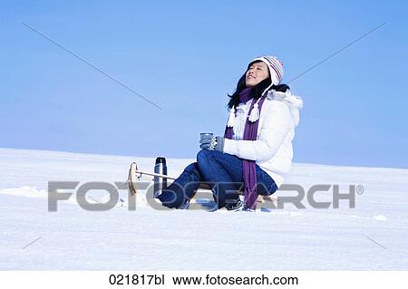 young asian woman sitting on sledge having drink from thermos bottle View Large Photo Image Stock Image - young asian woman sitting on sledge having drink from thermos bottle. Fotosearch