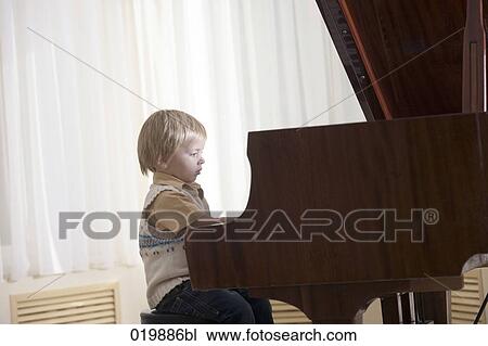 young boy playing piano at home View Large Photo Image Stock Image - young boy playing piano at home. Fotosearch