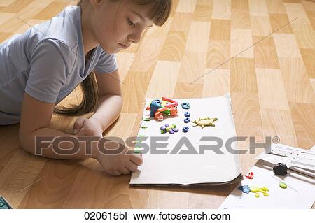young girl lying on floor playing with modelling clay View Large Photo Image Stock Image - young girl lying on floor playing with modelling clay. Fotosearch