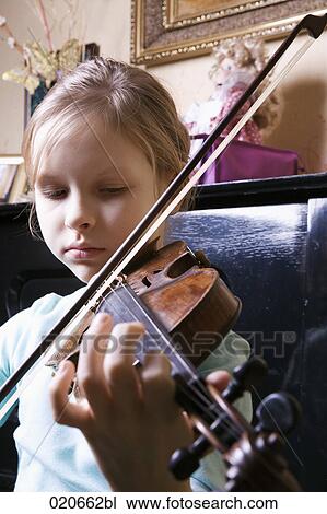 Stock Image - young girl playing violin at home. Fotosearch