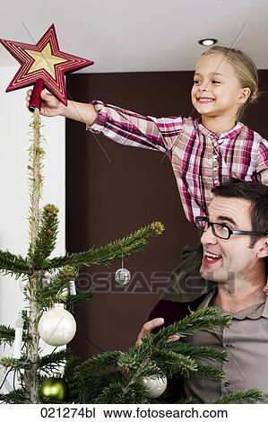 young girl putting star on top of christmas tree View Large Photo Image Stock Image - young girl putting star on top of christmas tree. Fotosearch