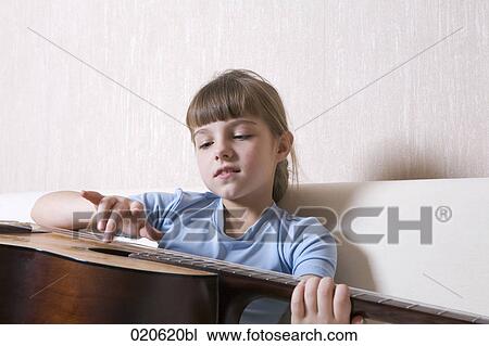 young girl sitting on sofa playing guitar View Large Photo Image Stock Image - young girl sitting on sofa playing guitar. Fotosearch