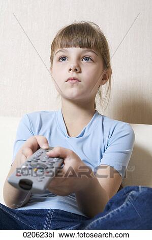 young girl sitting on sofa watching television View Large Photo Image Stock Image - young girl sitting on sofa watching television. Fotosearch