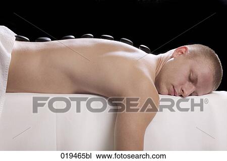 young man getting hot stone massage treatment View Large Photo Image Stock Image - young man getting hot stone massage treatment. Fotosearch