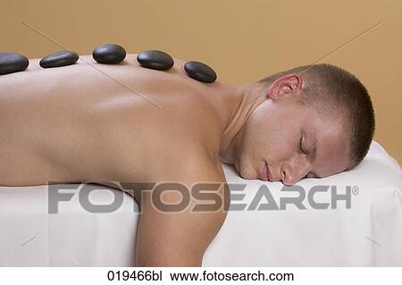 young man getting hot stone massage treatment View Large Photo Image Stock Image - young man getting hot stone massage treatment. Fotosearch