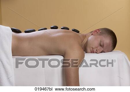 young man getting hot stone massage treatment View Large Photo Image Stock Image - young man getting hot stone massage treatment. Fotosearch