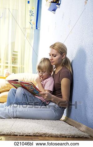 young mother reading from book to her son View Large Photo Image Stock Image - young mother reading from book to her son. Fotosearch