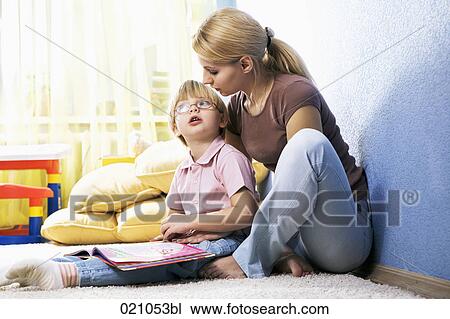 young mother reading from book to her son View Large Photo Image Stock Image - young mother reading from book to her son. Fotosearch