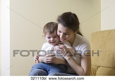 young mother sitting with her son on sofa View Large Photo Image Stock Image - young mother sitting with her son on sofa. Fotosearch