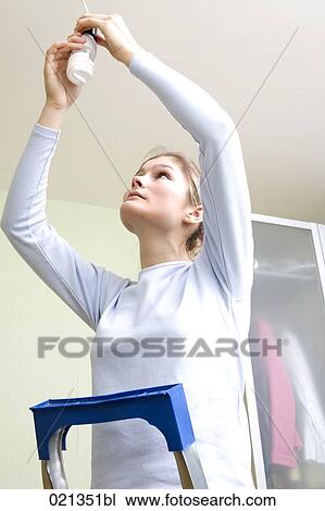 young woman fixing low energy light bulb View Large Photo Image Stock Image - young woman fixing low energy light bulb. Fotosearch