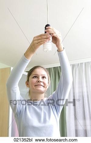 young woman fixing low energy light bulb View Large Photo Image Stock Image - young woman fixing low energy light bulb. Fotosearch