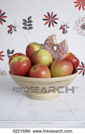 bitten donut in bowl full of apples View Large Photo Image Stock Image - bitten donut in bowl full of apples. Fotosearch