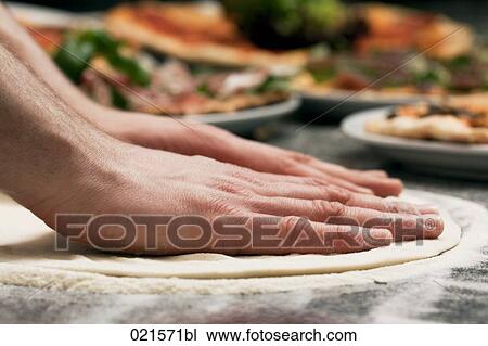 Stock Image - close-up of pizza baker making dough. Fotosearch