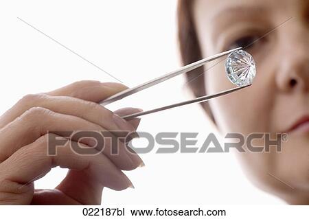 close-up of woman holding diamond with tweezers View Large Photo Image Stock Image - close-up of woman holding diamond with tweezers. Fotosearch