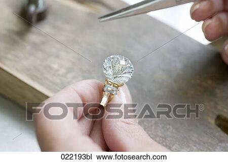 close-up of woman putting diamond on golden ring View Large Photo Image Stock Image - close-up of woman putting diamond on golden ring. Fotosearch