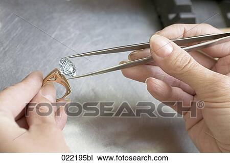 close-up of woman putting diamond on golden ring View Large Photo Image Stock Image - close-up of woman putting diamond on golden ring. Fotosearch