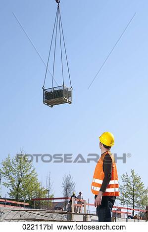 construction worker watching load being lifted by tower crane View Large Photo Image Stock Image - construction worker watching load being lifted by tower crane. Fotosearch