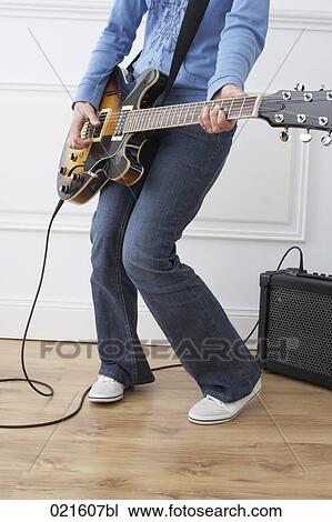 detail of woman playing electric guitar at home View Large Photo Image Stock Image - detail of woman playing electric guitar at home. Fotosearch