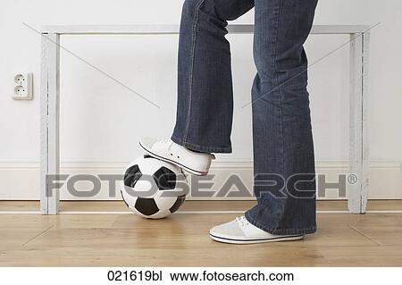Stock Image - detail of woman standing on football. Fotosearch