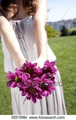 detail of youg woman holding bunch of purple flowers View Large Photo Image Stock Image - detail of youg woman holding bunch of purple flowers. Fotosearch