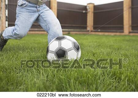 Stock Image - detail of young boy playing football. Fotosearch