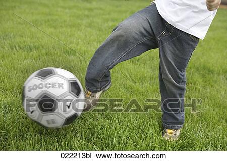 Stock Image - detail of young boy playing football. Fotosearch