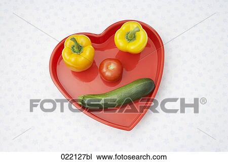 different vegetables in heart shaped tray forming face View Large Photo Image Stock Image - different vegetables in heart shaped tray forming face . Fotosearch