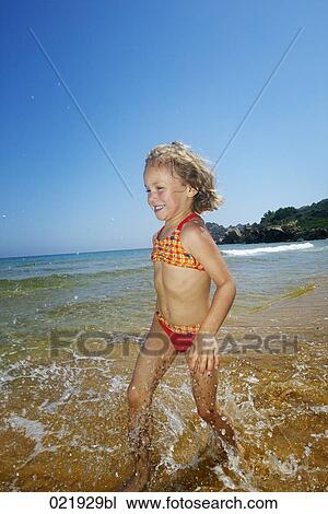 little girl running through surf on beach View Large Photo Image Stock Image - little girl running through surf on beach. Fotosearch