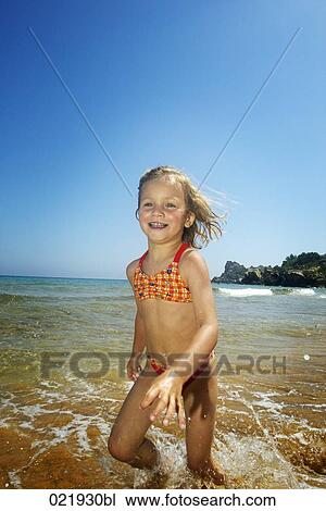 little girl running through surf on beach View Large Photo Image Stock Image - little girl running through surf on beach. Fotosearch