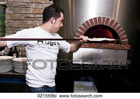 pizza baker putting pizza into oven View Large Photo Image Stock Image - pizza baker putting pizza into oven. Fotosearch