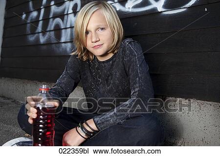 Stock Image - portrait of blond young boy with plastic bottle. Fotosearch
