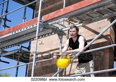 portrait of construction worker taking a break on scaffolding View Large Photo Image Stock Image - portrait of construction worker taking a break on scaffolding. Fotosearch