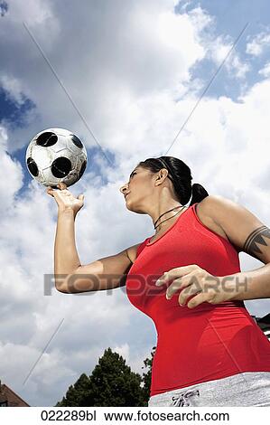 Stock Image - portrait of female football player balancing ball on finger. Fotosearch