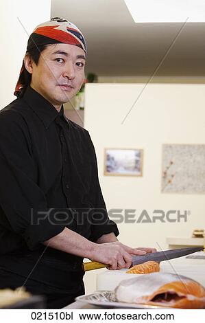Stock Image - portrait of japanese chef preparing sushi. Fotosearch