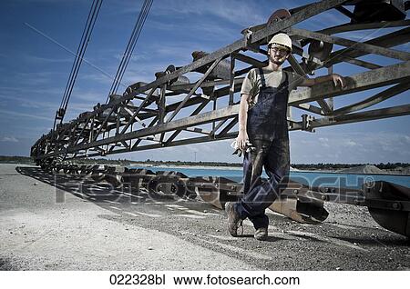 Stock Image - portrait of worker in front of excavator. Fotosearch