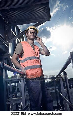 Stock Image - portrait of worker talking on mobile phone. Fotosearch