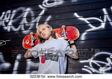 Stock Image - portrait of young boy with skateboard. Fotosearch