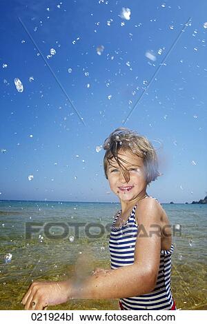 portrait of young girl on beach splashing water View Large Photo Image Stock Image - portrait of young girl on beach splashing water. Fotosearch