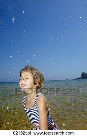 portrait of young girl on beach splashing water View Large Photo Image Stock Image - portrait of young girl on beach splashing water. Fotosearch