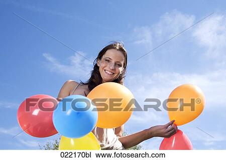 portrait of young woman holding colourful balloons View Large Photo Image Stock Image - portrait of young woman holding colourful balloons. Fotosearch