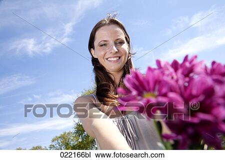 portrait of young woman in park with bunch of flowers View Large Photo Image Stock Image - portrait of young woman in park with bunch of flowers. Fotosearch
