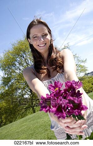 portrait of young woman in park with bunch of flowers View Large Photo Image Stock Image - portrait of young woman in park with bunch of flowers. Fotosearch